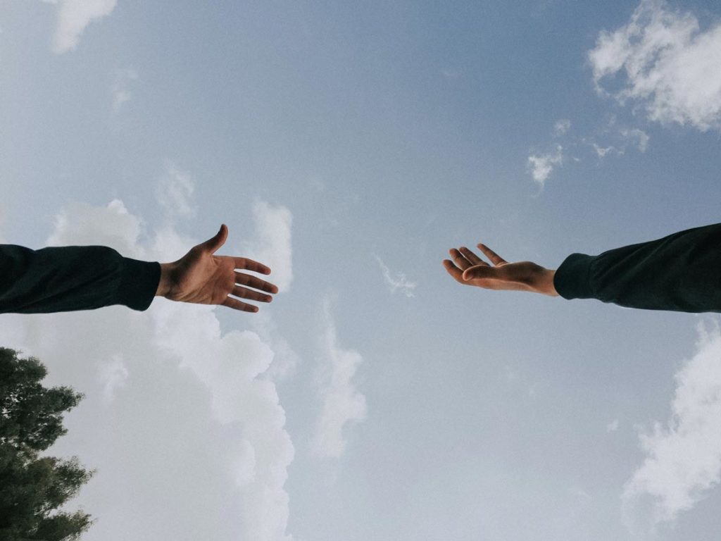 Deux mains de deux personnes différentes essayant de se toucher