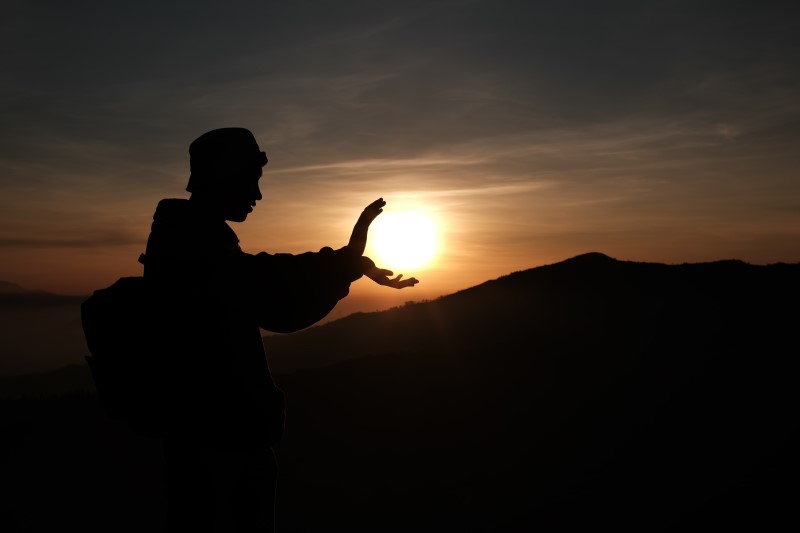 Pratiquant de taïchi tenant un coucher de soleil dans ses mains